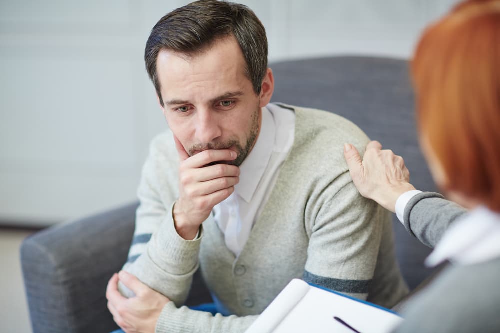 A counsellor offering reassurance to a man during a session